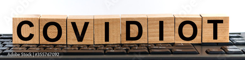 Fotografía COVIDIOT word made with building blocks on keyboard background