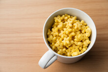Yellow Star Shaped Honey Coated Cereal Inside A Mug On A Wooden Table.