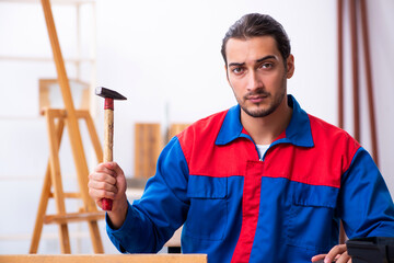 Young male contractor working in workshop