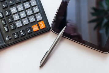 tablet, pen and calculator on white background