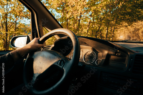 Persona dentro de un coche conduciendo a través del bosque en otoño-Person inside a car driving through the forest in autumn