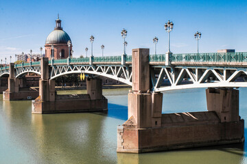 Wall Mural - Toulouse landmarks on the bank of river Garone. Hospital de La Grave and Ferries Wheel reflected in Garone river.