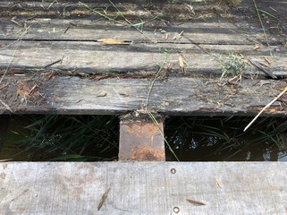 The hazard of an old broken bridge across a stream