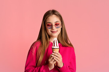 Wall Mural - Love for sweets. Funny teenager girl holds an ice cream looks at it and licks lips