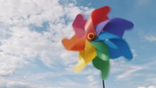 Pinwheel Rotating Colored Spinning Plastic With Blowing Wind Against Blue Sky And White Clouds Summer Sunny Day Slow Motion. Symbol Of Freedom And Childhood. Toy Spinner.  Relax