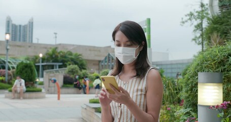 Wall Mural - Woman wear face mask and use of mobile phone at outdoor