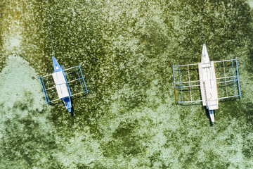 Top down aerial view of a two tourist boats over a tropical coral reef in a clear ocean