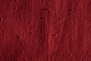 Wall Mural - Texture of a dark red linen fabric with many defects. Old uneven textile material for background. Closeup. Top view
