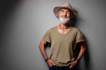 Wall Mural - Middle aged traveler. Studio portrait of handsome senior man with gray beard and hat.