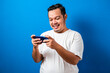 © Reza - Funny Fat Asian Guy Playing Games on Tablet Smart Phone against blue background