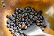 Roasted coffee beans in a brass pan