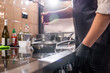 © pressmaster - Close-up of unrecognizable chef in apron standing at stove and salting food in pan