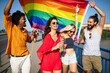 © NDABCREATIVITY - Pride homosexual, lesbian, gay community at a parade with hands raised and the LGBT flag