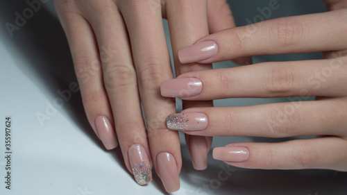 Fotografering Manicure on female hands with nude nail polish
