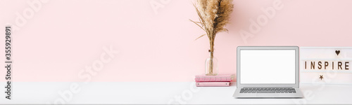 Fotografía Comfortable workplace with modern laptop near color wall with space for text
