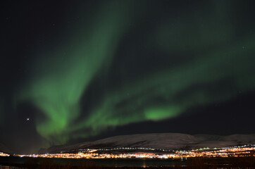 mighty northern light dancing over snowy mountain peak in northern norway on the whale island settle
