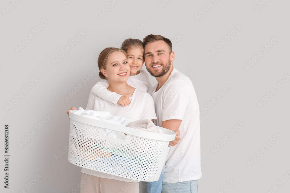 Family with laundry on grey background