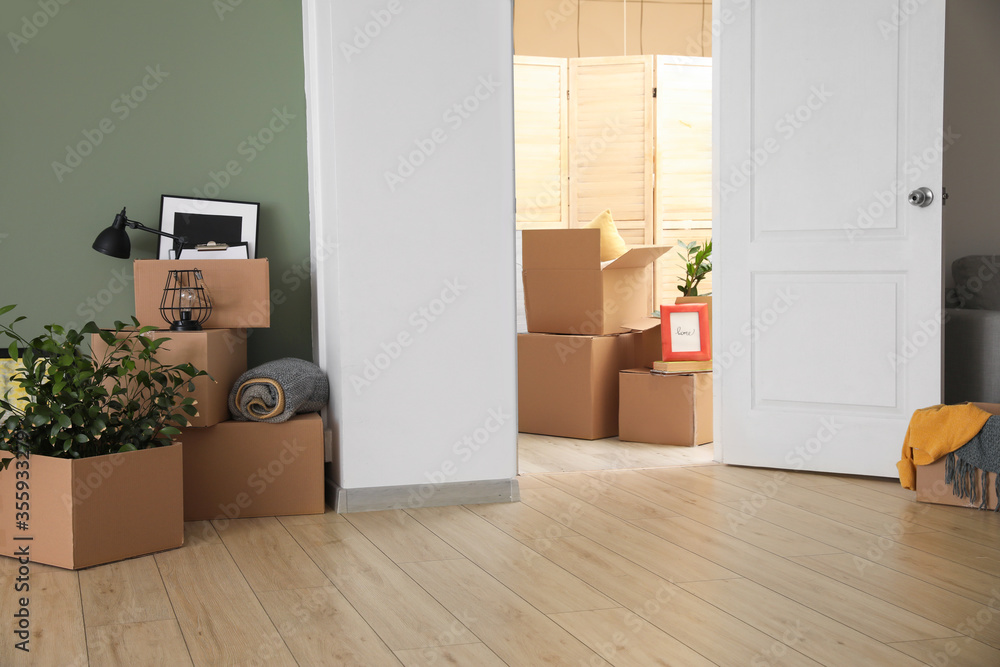Cardboard boxes with belongings in new flat on moving day