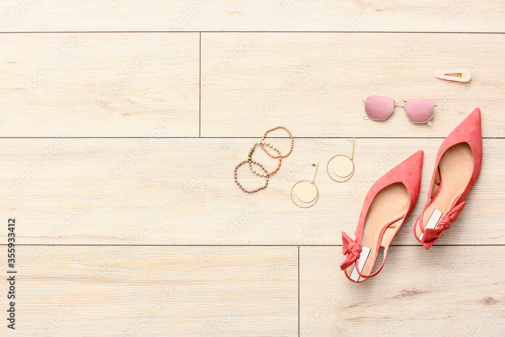 Set of female accessories on light wooden background