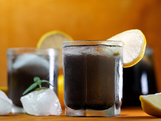 Wall Mural - Black lemonade with mint, lemon, charcoal and ice on a wooden table