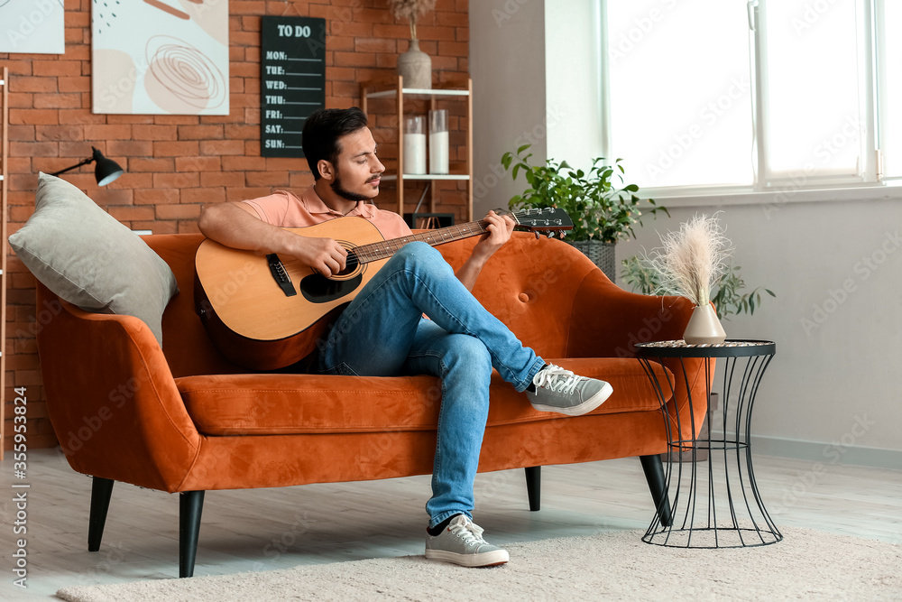 Handsome young man playing guitar at home Stock Photo | Adobe Stock