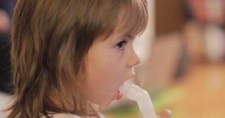 beautiful little girl inhaling herself with a nebulizer