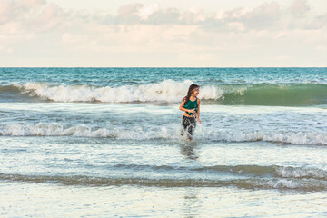 Child running in the water on the beach on a beautiful day