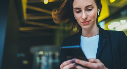 Wall Mural - Portrait female entrepreneur in corporate suit using online banking via smartphone. Confident businesswoman texting email letter on cellphone using internet on background modern office