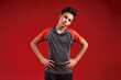 © Svitlana - Time to train. A teenage boy is engaged in fitness, he is looking at camera while doing exercise. Isolated on red background. Sport, training, fitness, active lifestyle concept. Horizontal shot