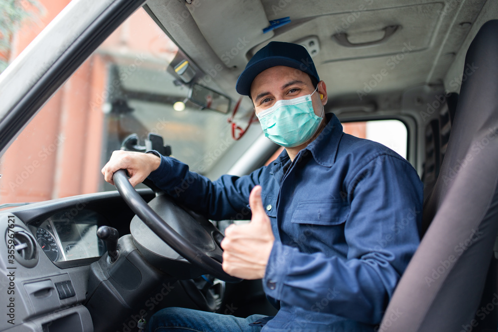 Truck driver giving thumbs up during coronavirus pandemic - obrazy, fototapety, plakaty 