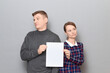 © Andrei Korzhyts - Portrait of adult couple holding together white blank paper sheet