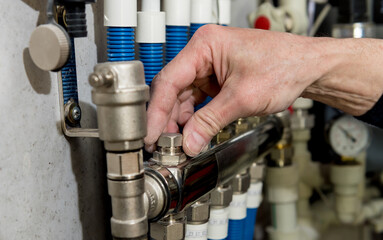 Heating engineer fixing modern heating system in boiler room. 