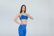 © Andrii - Sexy young girl posing in a blue tracksuit on a white background. Fitness, healthy lifestyle