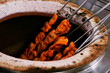 spice marinated chicken cubes ( chicken tikka )skewers cooking in a clay oven known as tandoor
