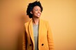 © Krakenimages.com - Young beautiful African American afro businesswoman with curly hair wearing yellow jacket looking away to side with smile on face, natural expression. Laughing confident.