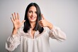 © Krakenimages.com - Young brunette woman with blue eyes wearing casual t-shirt over isolated white background showing and pointing up with fingers number six while smiling confident and happy.
