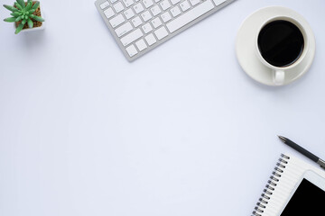 Wall Mural - Workspace in office with white table. Top view from above of keyboard with notebook and coffee. Desk for modern creative work of designer. Flat lay with blank copy space. Business and finance concept.