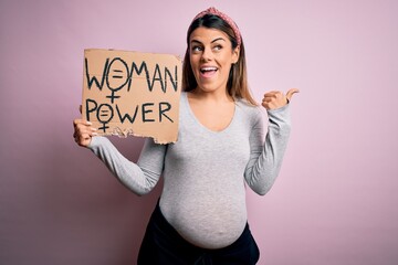 Sticker - Young brunette woman pregnant expecting baby holding banner asking for women power pointing and showing with thumb up to the side with happy face smiling