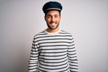 Young Handsome Sailor Man With Beard Wearing Navy Striped Uniform And Captain Hat With A Happy And Cool Smile On Face. Lucky Person.