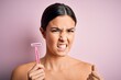 © Krakenimages.com - Young beautiful girl using shaver for depilation standing over isolated pink background annoyed and frustrated shouting with anger, crazy and yelling with raised hand, anger concept