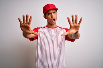 Young handsome african american sportsman wearing striped baseball t-shirt and cap doing stop gesture with hands palms, angry and frustration expression