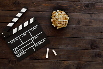 Filmmaking concept. Movie Clapperboard. Cinema begins with movie clappers. Movie clapper on a wooden background and popcorn.