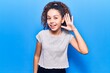 © Krakenimages.com - Beautiful kid girl with curly hair wearing casual clothes smiling with hand over ear listening and hearing to rumor or gossip. deafness concept.