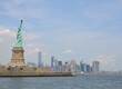 statue of liberty in New York with water and ferries