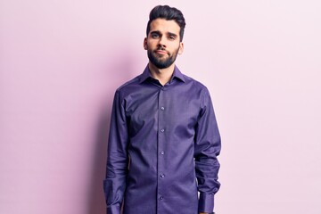 Young handsome man with beard wearing casual shirt relaxed with serious expression on face. simple and natural looking at the camera.