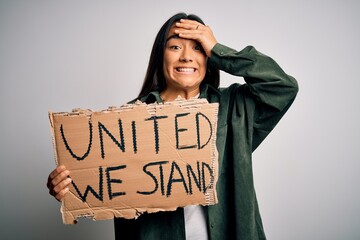 Canvas Print - Young beautiful activist asian woman asking unity holding banner with united stand message stressed with hand on head, shocked with shame and surprise face, angry and frustrated. Fear and upset