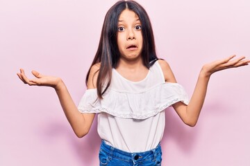 Wall Mural - Beautiful child girl wearing casual clothes clueless and confused with open arms, no idea and doubtful face.