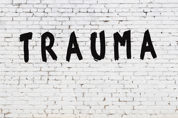 Wall Mural - Word trauma painted on white brick wall