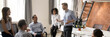 © fizkes - Multi ethnic corporate staff listen team leader company boss during morning briefing in coworking open space office. Mentoring, brainstorming concept. Horizontal photo banner for website header design