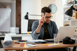 © JustLife - Young businessman using laptop in his office. Businessman working and taking notes.